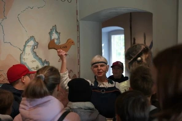 Sieviete vada ekskursiju Turaidas pilī