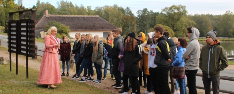Izglītojošā programma Latviešu valoda – manas valsts valoda. Vadītāja vada ekskursiju skolēnu grupai. 