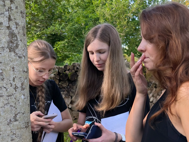Lapkoku daudzveidības salīdzināšana Turaidas muzejrezervāta meža parkā un Lībiešu takā 7.–9. kl. skolēniem. Trīs meitenes , divas skatās telefonā.