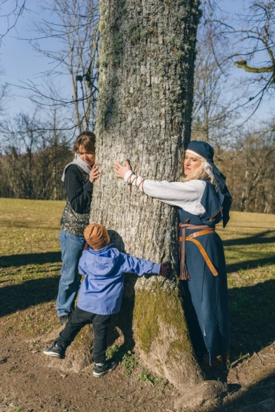 Women and two children hugging tree