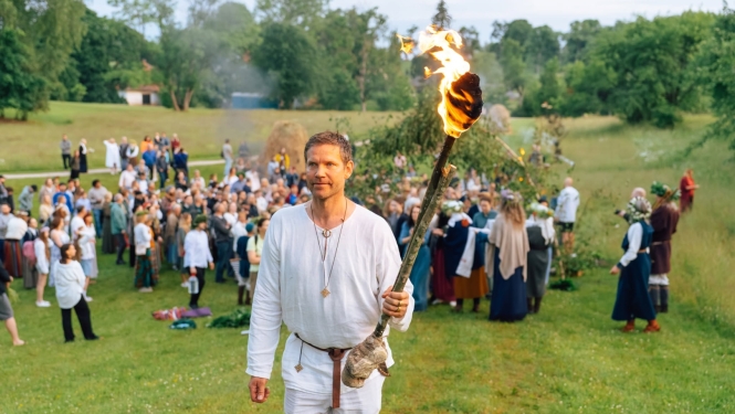 Jāņu dienas pasākums Turaidā. Jauns vīrietis ar lāpu