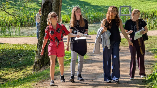 alt="Lapkoku daudzveidības salīdzināšana Turaidas muzejrezervāta meža parkā un Lībiešu takā 7.–9. kl. skolēniem. Četras meitenes iet pa taciņu"