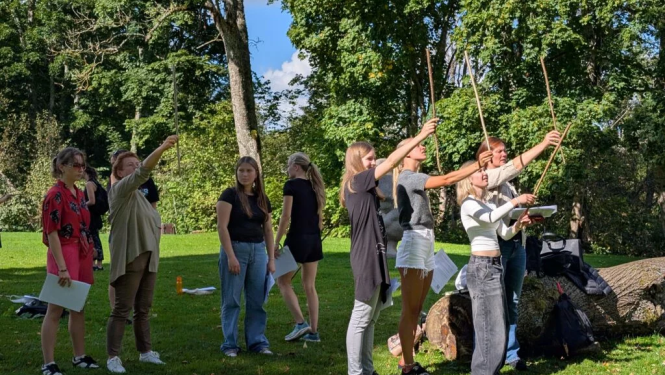 Koksnes krājas salīdzināšana kokiem Turaidas muzejrezervāta meža parkā (10.–12. kl.). Jaunieši pēta koku zarus.