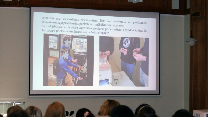 Cilvēki sēž zālē, konferencē