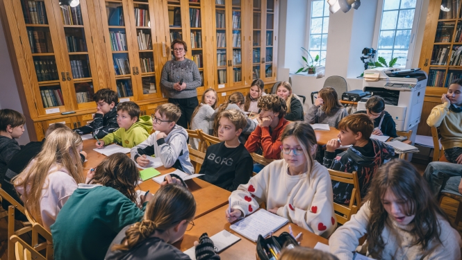 Skolēni pie galda Turaidas muzejrezervāta krājumā