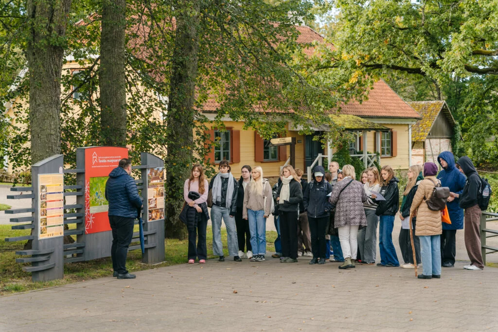 Dainu kalns – vieta līdzdalībai. Skolnieku grupa klausās vadītāja stāstījumu.
