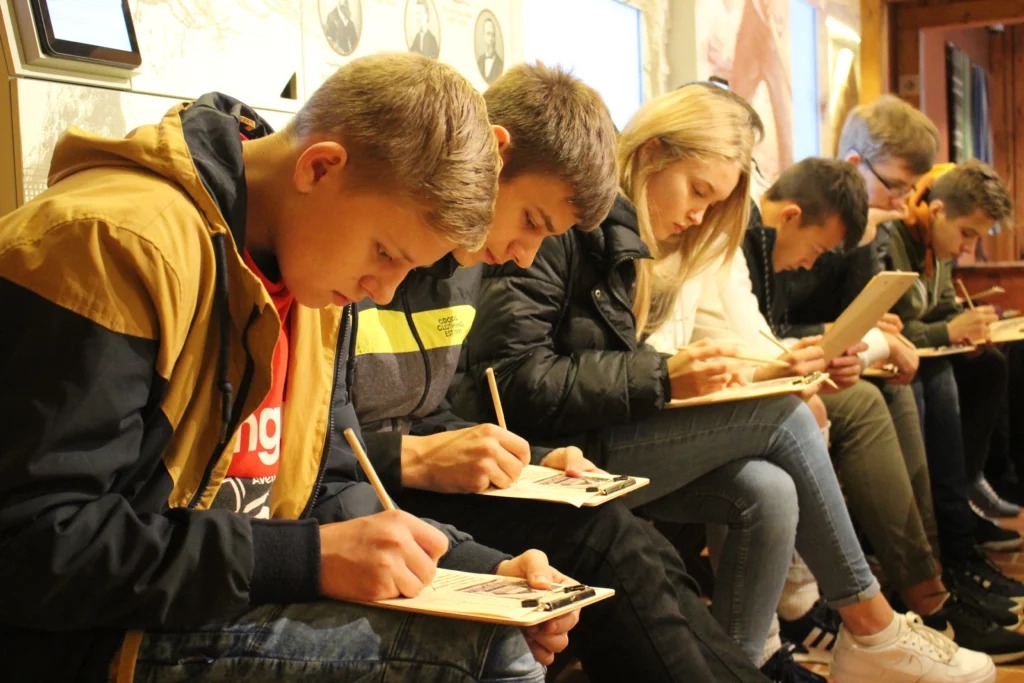 Izglītojošā programma Latviešu valoda – manas valsts valoda. SkolniekU grupa rakstiski aizpilda atjautības uzdevumus.