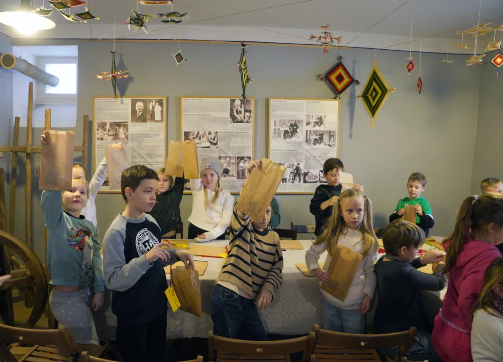 Muzejpedagoģiskās programma Ziemassvētki Turaidas muižā. Skolnieku grupa rāda savas izveidotās dekorācijas. 