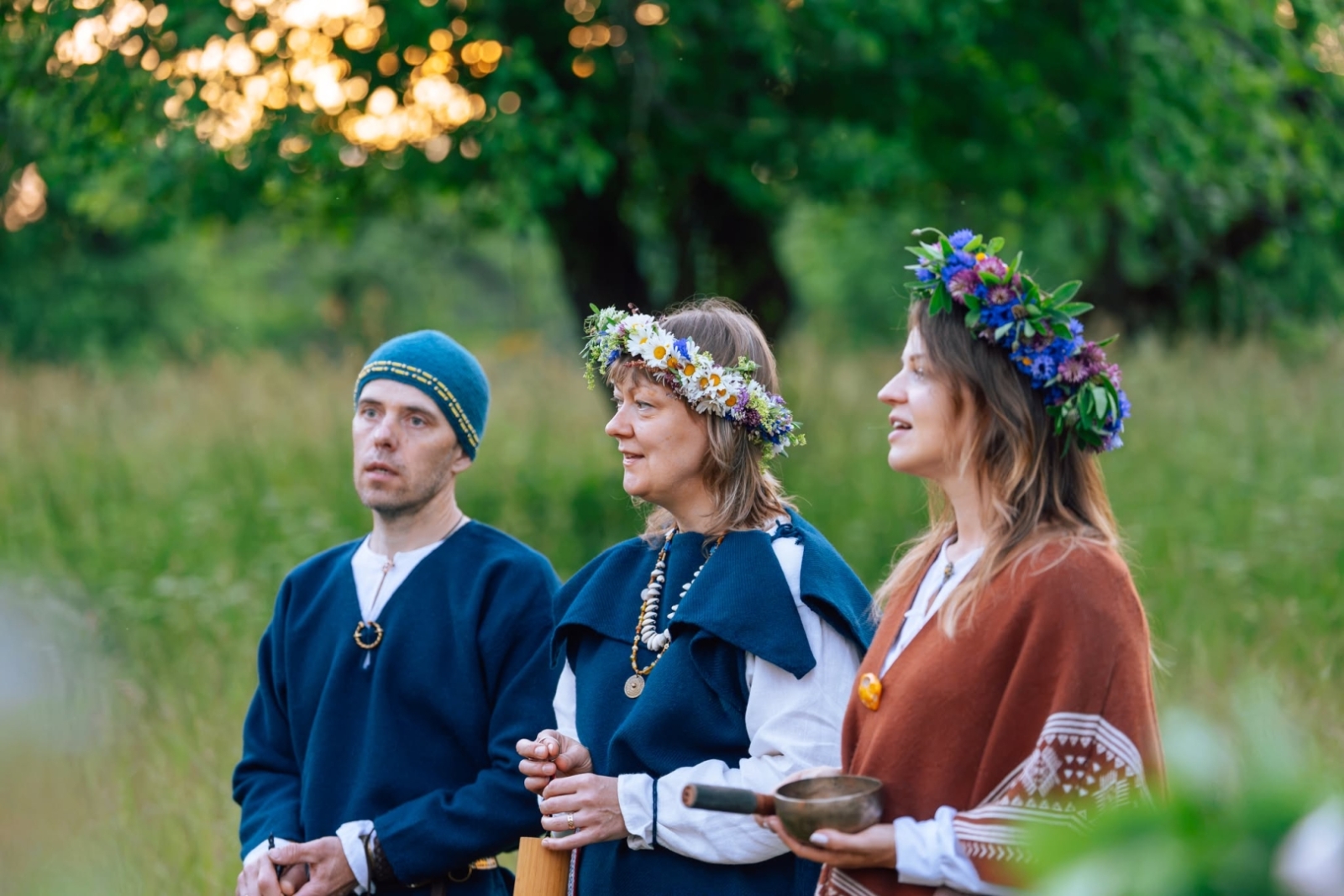 Jāņu dienas pasākums Turaidā. Divas sievietes ar vainagiem un vīrietis blakus