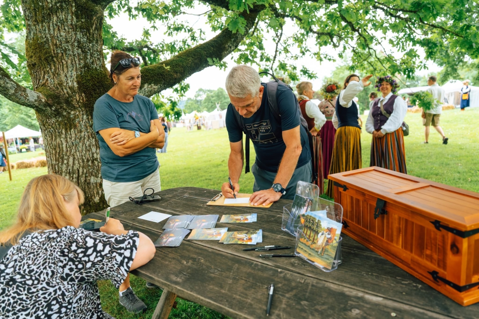 Jāņu dienas pasākums Turaidā. Vīrietis paraksta pastkarti