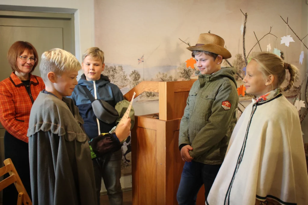 Muzejpedagoģiskās programma Uzvārdu došana Vidzemē Vadītāja skatās uz skolēnu grupu apmetņos 