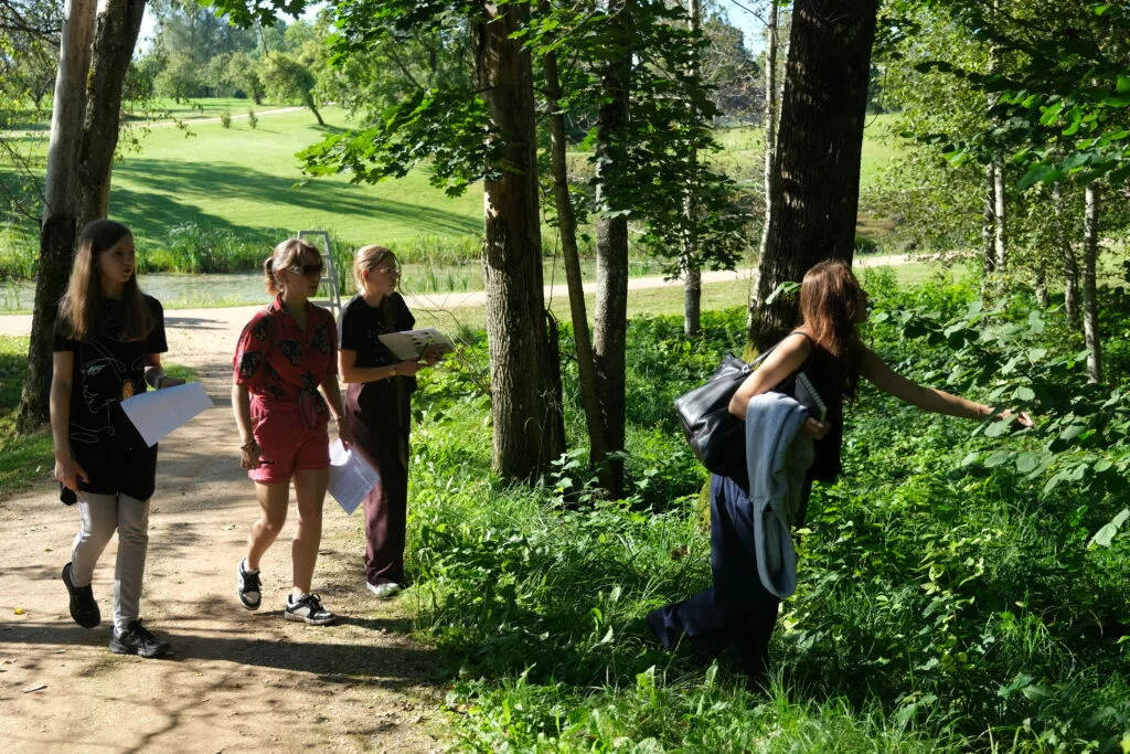 Lapkoku daudzveidības salīdzināšana Turaidas muzejrezervāta meža parkā un Lībiešu takā (7.–9. kl.) Skolnieku grupa muzejrezervāta parkā  klausās vadītājas stāstījumā