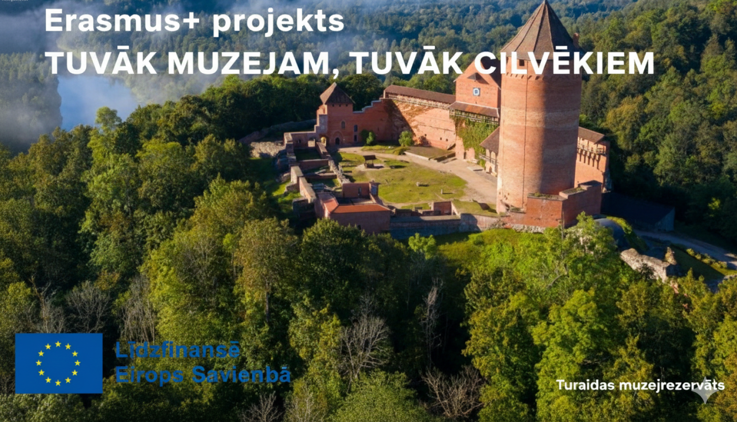 Turaidas pils skats no putna lidojuma rīta saules gaismā un informācija par Erasmus+ projektu "Tuvāk muzejam, tuvāk cilvēkiem" ar Eiropas Savienības līdzfinansējuma logo.