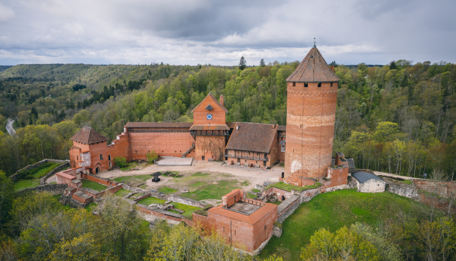 Turaidas pils skats no putna lidojuma un paziņojums par jaunu maksas pakalpojumu cenrādi muzejrezervātā.