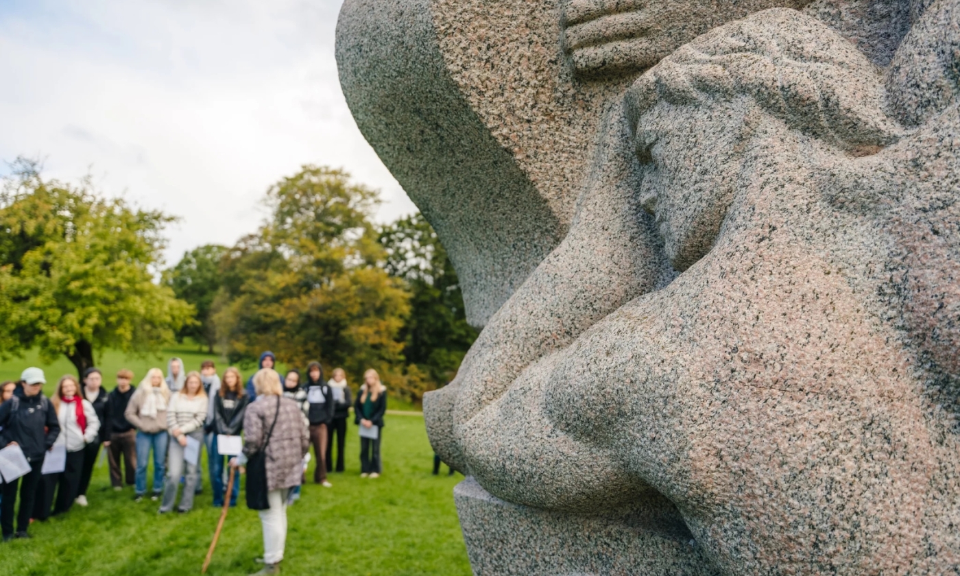 Dainu kalns –  vieta līdzdalībai. Skolnieku grupa Dainu kalna parkā klausās vadītājas stāstījumā.