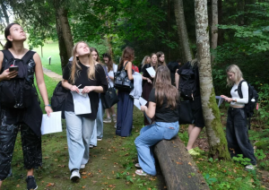 Koksnes krājas salīdzināšana kokiem Turaidas muzejrezervāta meža parkā 7.–9. klašu skolēniem. Skolnieku grupa pēta kokus.