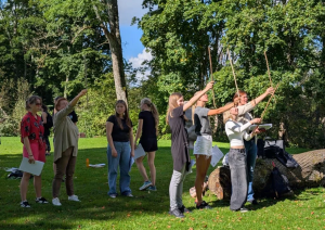 Koksnes krājas salīdzināšana kokiem Turaidas muzejrezervāta meža parkā (10.–12. kl.). Jaunieši pēta koku zarus.